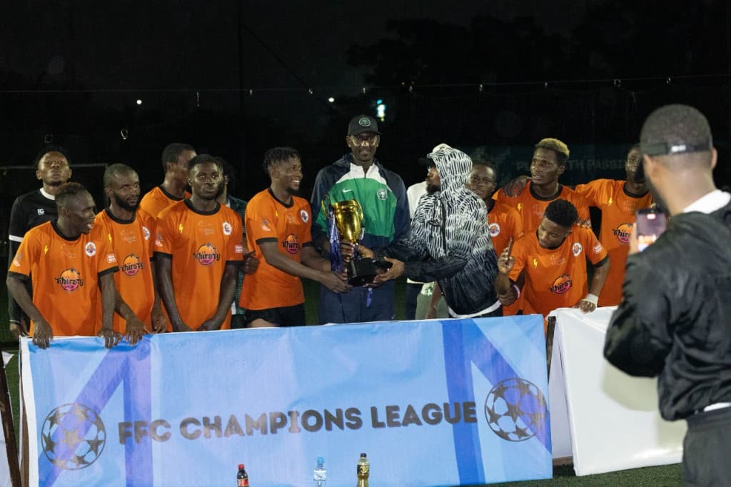 FFC Champions League winners lifting the trophy behind the league banner